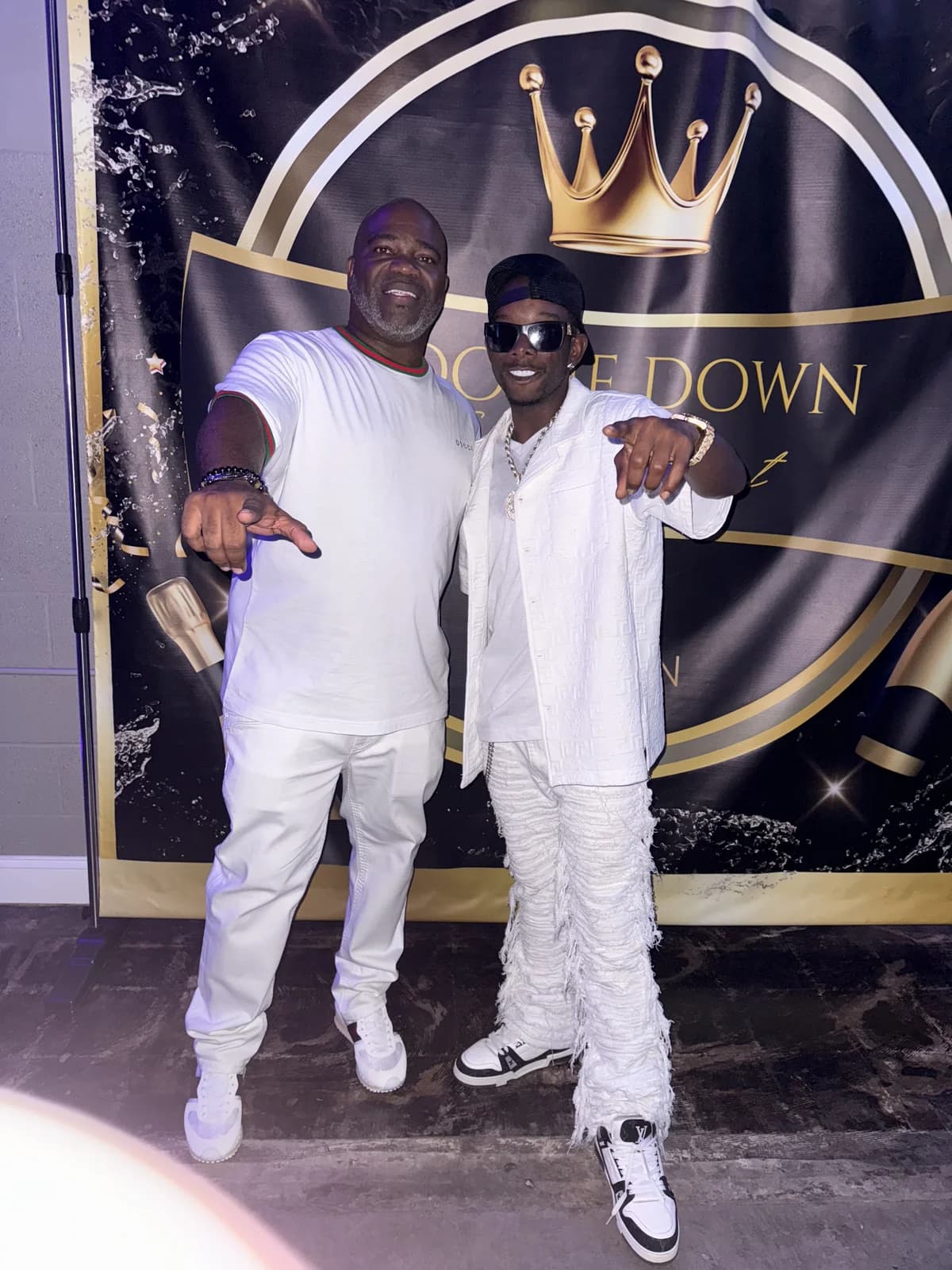 Marcus Banks and Danny Boy posing in front of a Boogie Down step-and-repeat backdrop